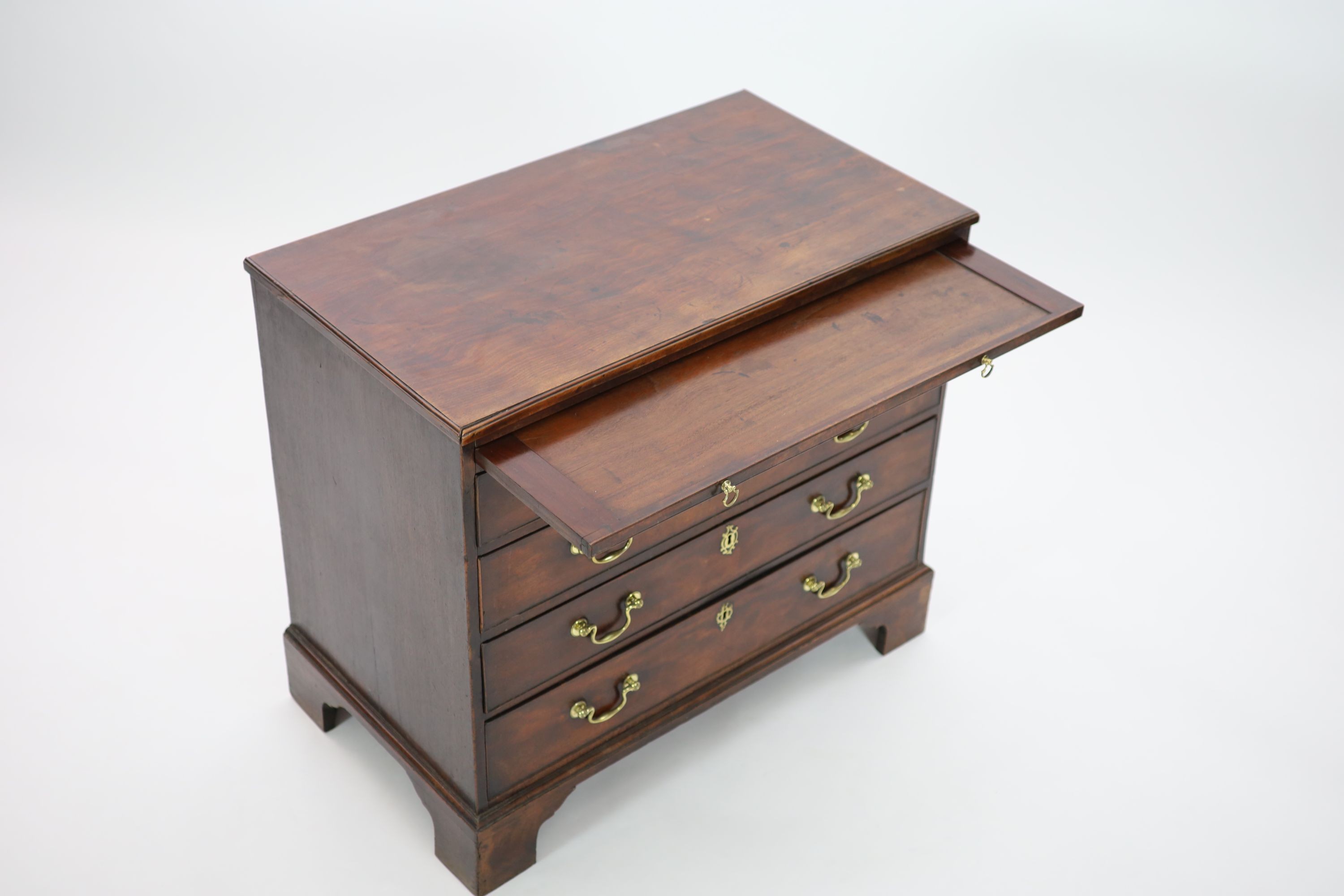 A George III mahogany chest of four graduated long drawers with brushing slide W 93cm D 52cm. H 83cm.